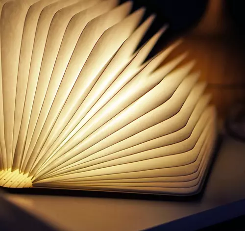 Die Buchlampe erhellt den Raum in warmen Licht